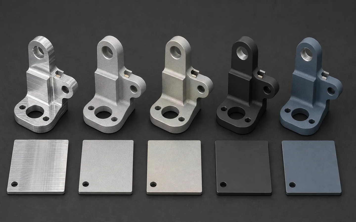 Five matching metal brackets and coupons shown in as-machined, blasted, conversion-style, matte dark and blue-gray coated surface conditions.